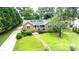 Charming brick home with a manicured lawn, stone walkway, and solar panels on the roof at 8259 Camelia Ln, Denver, NC 28037