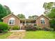 Welcoming brick home with arched windows, charming front porch, and lush landscaping at 8259 Camelia Ln, Denver, NC 28037
