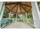 Inviting gazebo boasts a charming wood ceiling, white columns, and views of a lush landscaped yard at 8259 Camelia Ln, Denver, NC 28037