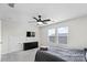 Well-lit bedroom with a ceiling fan, two windows, a mounted television, and a dark dresser at 9009 Myrna Dr, Gastonia, NC 28056