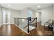 Bright hallway with hardwood floors, iron railing, and natural light from a window at 9511 Spurwig Ct, Charlotte, NC 28278