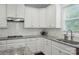 Well-lit kitchen with granite countertops, subway tile backsplash, and ample cabinet space at 9511 Spurwig Ct, Charlotte, NC 28278
