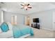 Bright main bedroom featuring a tray ceiling, a fan, and ensuite bathroom at 9511 Spurwig Ct, Charlotte, NC 28278
