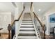 Stylish staircase with dark wood handrailings and a light color on risers and walls at 9511 Spurwig Ct, Charlotte, NC 28278