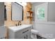 Charming bathroom with a modern sink, mirror, wooden wall, and floating wooden shelves at 1010 Fallston Rd, Shelby, NC 28150