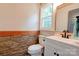 Stylish bathroom featuring a stone wall, mirror, vanity, and toilet at 1010 Fallston Rd, Shelby, NC 28150