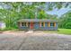 Charming single-story home featuring a brick facade, orange door, and yellow shutters at 1010 Fallston Rd, Shelby, NC 28150