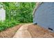 The side of a gray brick house has a stone walkway and mature trees at 1010 Fallston Rd, Shelby, NC 28150