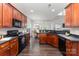 Well-maintained kitchen featuring wood cabinets, black appliances, and a view into the dining area at 10198 Tintinhull Dr, Fort Mill, SC 29707