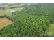 Aerial view showcasing home bordering vast forest area with lush green trees at 1060 S Lentz Harness Shop Rd, Mount Pleasant, NC 28124