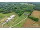 Property aerial featuring a large home, barn, and surrounding lush greenery at 1060 S Lentz Harness Shop Rd, Mount Pleasant, NC 28124
