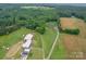 Sprawling aerial view showcasing a home with acreage, barn, and surrounding greenery at 1060 S Lentz Harness Shop Rd, Mount Pleasant, NC 28124