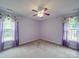 Sunny bedroom with carpet, two windows and stylish violet curtains for a peaceful and inviting interior space at 1060 S Lentz Harness Shop Rd, Mount Pleasant, NC 28124