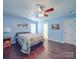 Cozy bedroom with wood floors, ceiling fan, a queen-size bed and natural light creates a serene atmosphere at 1060 S Lentz Harness Shop Rd, Mount Pleasant, NC 28124