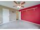 This bedroom features a ceiling fan, vibrant red accent wall, and ample closet space at 1060 S Lentz Harness Shop Rd, Mount Pleasant, NC 28124