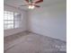 Cozy bedroom with neutral carpet, a ceiling fan with lights, and a window offering natural light and outside views at 1060 S Lentz Harness Shop Rd, Mount Pleasant, NC 28124