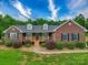 Charming brick home featuring a well-manicured lawn, mature landscaping, and a cozy front porch at 1060 S Lentz Harness Shop Rd, Mount Pleasant, NC 28124