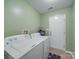 Functional laundry room features a white washer and dryer with a tiled floor and access to the exterior at 1060 S Lentz Harness Shop Rd, Mount Pleasant, NC 28124