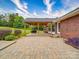 Brick paved patio with outdoor seating space and covered area attached to brick home creates a private backyard oasis at 1060 S Lentz Harness Shop Rd, Mount Pleasant, NC 28124