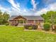 View of a beautiful home featuring a large backyard, covered patio and fire pit at 1060 S Lentz Harness Shop Rd, Mount Pleasant, NC 28124