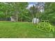 Spacious backyard includes a storage shed, green house, and play structure, creating a Gathering-friendly outdoor space at 1119 Thornsby Ln, Matthews, NC 28105