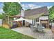 Backyard features a brick patio, covered deck, and a dining set perfect for outdoor relaxation and entertaining at 1119 Thornsby Ln, Matthews, NC 28105