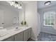 Bathroom featuring large mirror, vanity, white sink, decorative tile floor, and walk-in shower at 1119 Thornsby Ln, Matthews, NC 28105