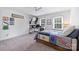 Bedroom features a ceiling fan, two windows, desk, and a bed with storage drawers underneath at 1119 Thornsby Ln, Matthews, NC 28105
