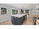 Bright kitchen featuring a large island with seating, stainless steel appliances, and an adjacent door at 1119 Thornsby Ln, Matthews, NC 28105