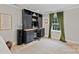 Home office with built-in shelving, desk space, a large window, and green drapes at 1119 Thornsby Ln, Matthews, NC 28105