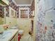 Cozy bathroom with floral wallpaper, tiled walls, and vintage fixtures; ready for modernization at 121 Patrick St, Gastonia, NC 28054