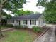 Low angle view of cozy one-story home with a well-maintained lawn and driveway at 121 Patrick St, Gastonia, NC 28054