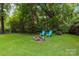 A peaceful backyard retreat featuring a rock fire pit and two Adirondack chairs at 1369 Timberlane Ter, Mooresville, NC 28115