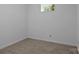 A small, unfinished basement room with a window, beige carpet, and white walls at 1369 Timberlane Ter, Mooresville, NC 28115