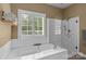 Elegant bathroom showcasing a soaking tub, a glass-enclosed shower, and bright window for a luxurious experience at 1369 Timberlane Ter, Mooresville, NC 28115