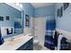 Vibrant bathroom featuring bright blue walls and vanity, complete with a shower-tub combo and coastal decor at 1369 Timberlane Ter, Mooresville, NC 28115
