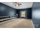 Spacious bedroom features neutral carpeting, shelf accent, a ceiling fan and a window with striped curtains at 1369 Timberlane Ter, Mooresville, NC 28115