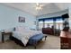 Comfortable bedroom with blue walls and a tray ceiling with a ceiling fan, providing a serene and relaxing ambiance at 1369 Timberlane Ter, Mooresville, NC 28115