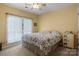 Cozy bedroom features floral bedding, a bedside table, and large window that allows ample natural light to illuminate the room at 1369 Timberlane Ter, Mooresville, NC 28115