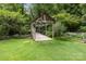 An arched wood bridge, grassy area and fenced area surrounded by lush landscaping at 1369 Timberlane Ter, Mooresville, NC 28115