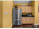 Well-lit kitchen features a stainless steel refrigerator, wooden cabinets, granite counter tops, and hard wood floors at 1369 Timberlane Ter, Mooresville, NC 28115