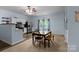 Well-lit kitchen and dining area with stainless steel appliances, white cabinets, and a window overlooking the backyard at 1369 Timberlane Ter, Mooresville, NC 28115