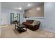 Cozy living room with a plush brown sofa, a wooden coffee table, and natural light from the window at 1369 Timberlane Ter, Mooresville, NC 28115
