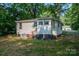 View of backyard showing the home's exterior, manicured lawn, and a wooded area at 143 Hallman St, Cherryville, NC 28021