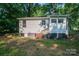 Cozy single-Gathering home featuring wood siding, a small deck, and a lush, tree-filled backyard at 143 Hallman St, Cherryville, NC 28021