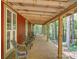 Spacious porch with wooden floors and supports offers a relaxing view of the surrounding woods at 157 Old Hearth Rd, Clover, SC 29710