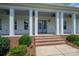 Covered front porch with brick steps and white columns, enhanced by ceiling fans at 1621 Lakefield Cir, Gastonia, NC 28056