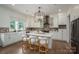 Bright, modern kitchen features an island with seating, brick backsplash, and stainless steel appliances at 1621 Lakefield Cir, Gastonia, NC 28056