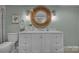 A bathroom featuring a toilet, sink, cabinets and vanity with a circular mirror at 1747 30Th Avenue Ne Dr, Hickory, NC 28601