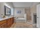 Bathroom featuring dual sinks, glass enclosed shower, and a soaking tub beneath a window at 1747 30Th Avenue Ne Dr, Hickory, NC 28601